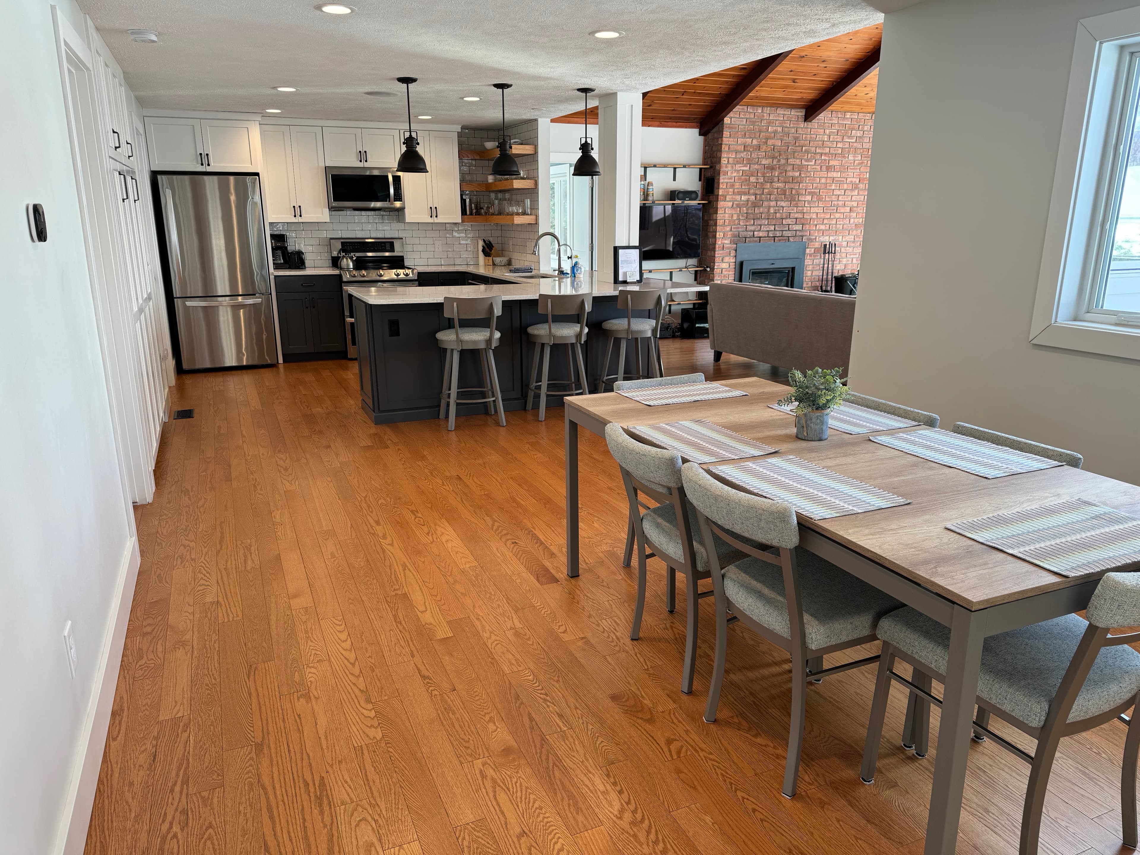Kitchen and dining area with six-seat dining table, pendant lights, and stainless steel appliances