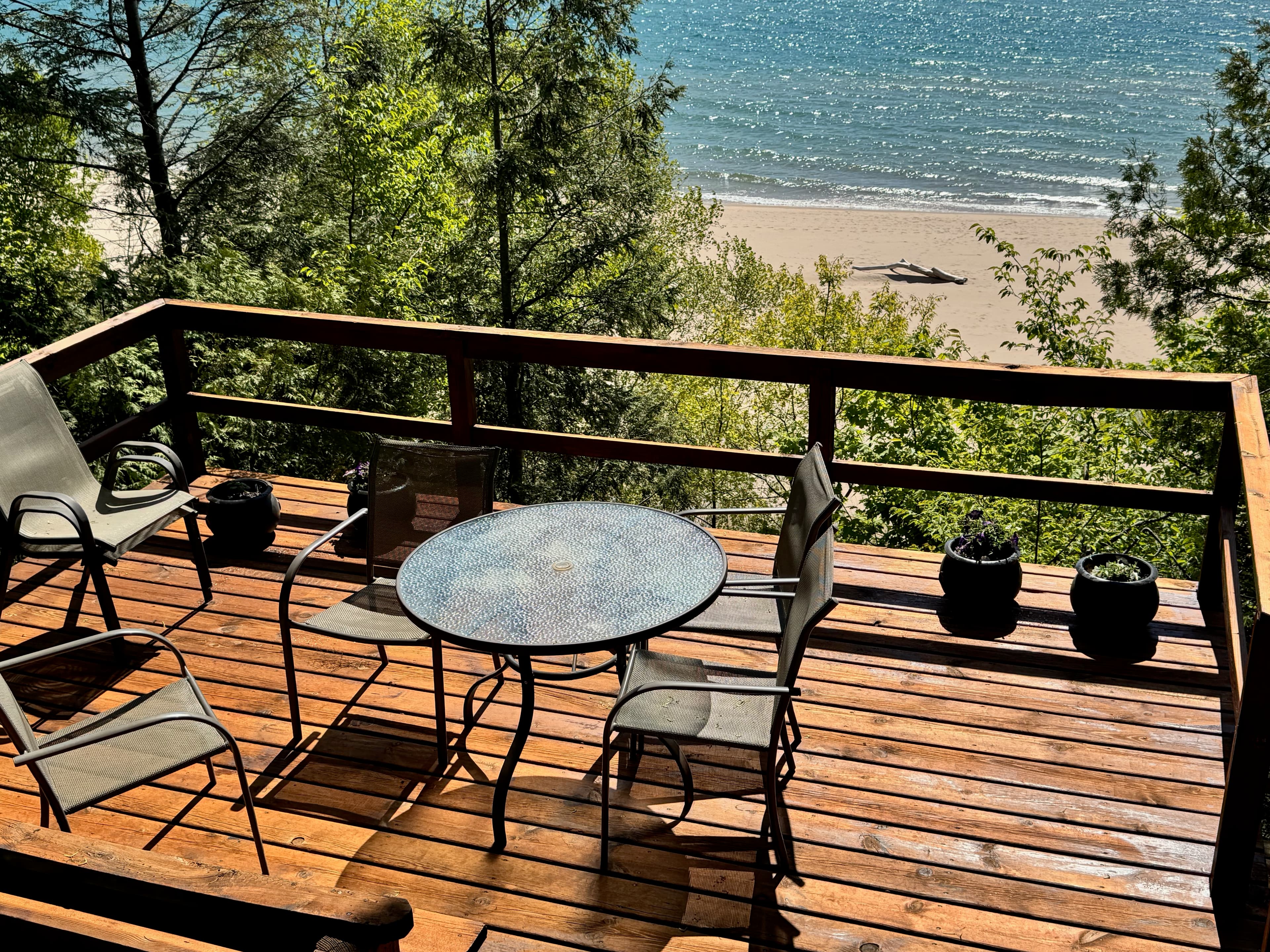 Upper deck with bistro table and chairs overlooking private beach and Lake Michigan